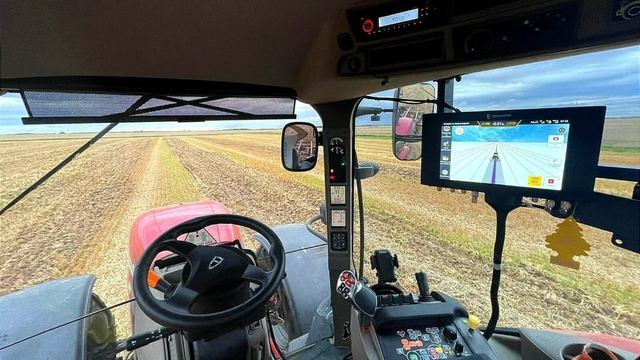 Cabine de trator com piloto automático e monitor mostrando a linha de passada